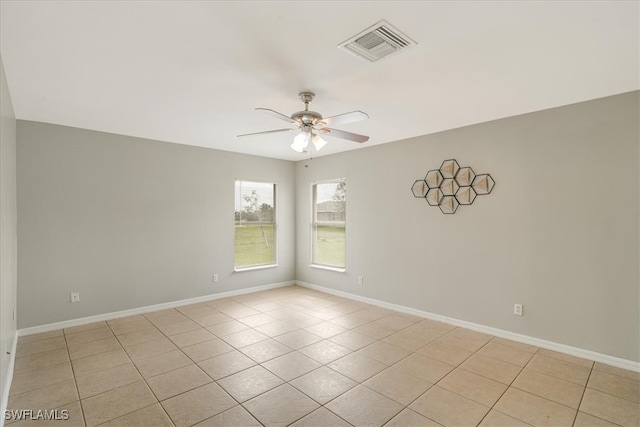 tiled spare room featuring ceiling fan