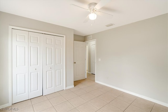 unfurnished bedroom featuring light tile patterned floors, a closet, and ceiling fan