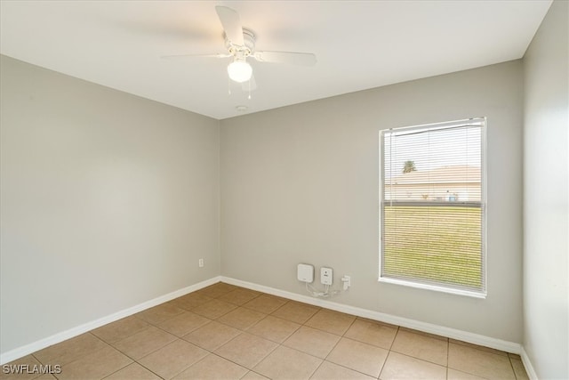 tiled empty room with ceiling fan and plenty of natural light