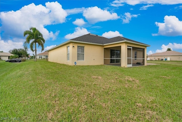 back of house featuring a sunroom and a lawn