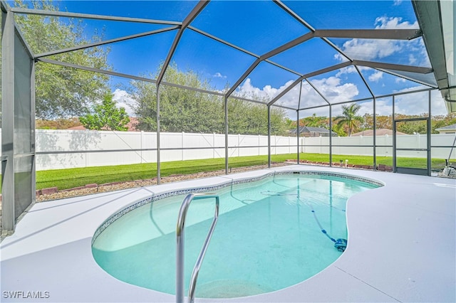 view of swimming pool featuring a yard, a patio area, and glass enclosure