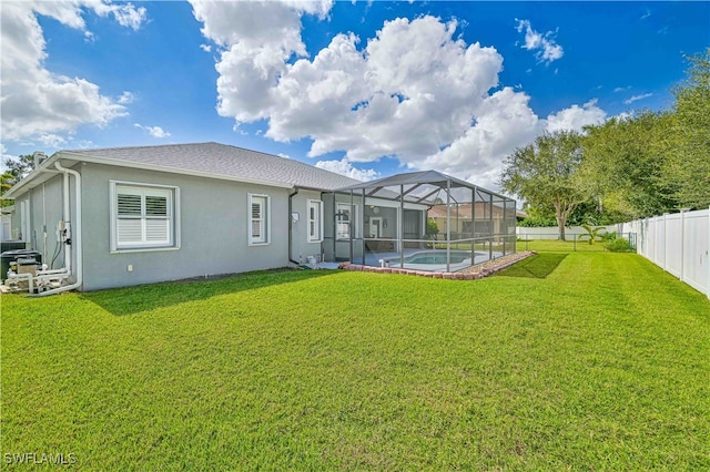 rear view of house with a fenced in pool, a lawn, and glass enclosure