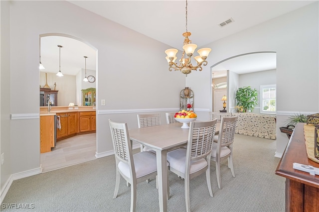 dining area with light carpet and an inviting chandelier