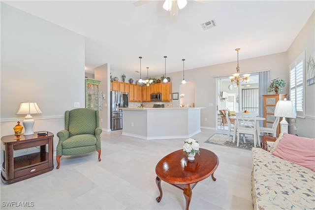 living room with ceiling fan with notable chandelier