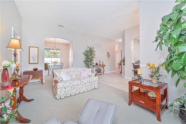 living room with light colored carpet and a chandelier