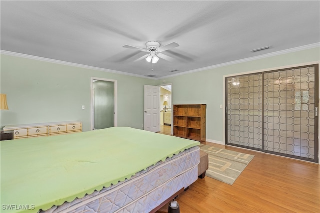 bedroom featuring a textured ceiling, hardwood / wood-style flooring, ceiling fan, and crown molding