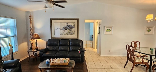 tiled living room with ceiling fan, plenty of natural light, and lofted ceiling