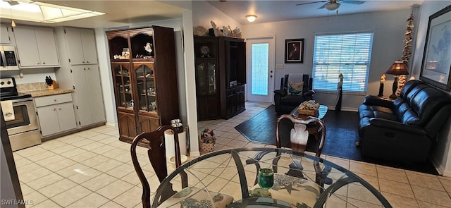 kitchen featuring ceiling fan, white cabinetry, stainless steel electric range oven, and light tile patterned floors