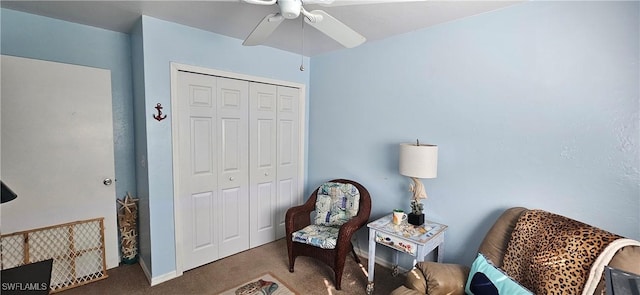 living area with ceiling fan and dark colored carpet