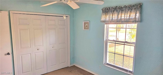 unfurnished bedroom featuring carpet floors, a closet, multiple windows, and ceiling fan