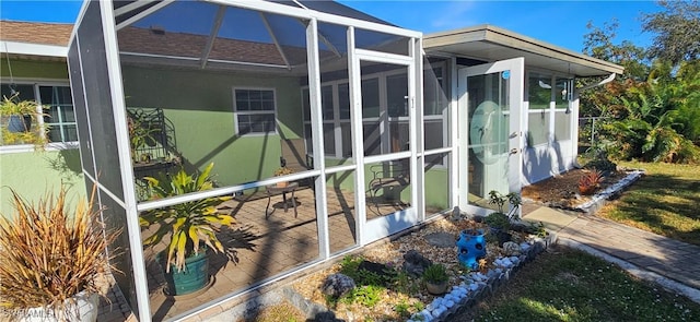 view of side of home featuring glass enclosure