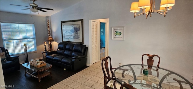 living room featuring tile patterned floors, ceiling fan with notable chandelier, and vaulted ceiling