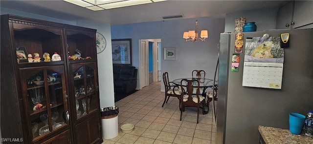 tiled dining room featuring a chandelier