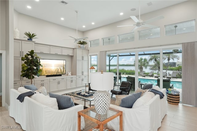 living room featuring ceiling fan, high vaulted ceiling, and light wood-type flooring