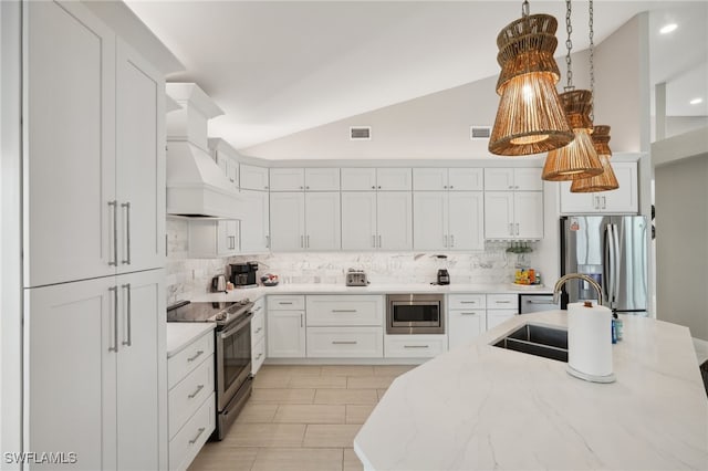 kitchen with backsplash, white cabinetry, stainless steel appliances, lofted ceiling, and custom exhaust hood