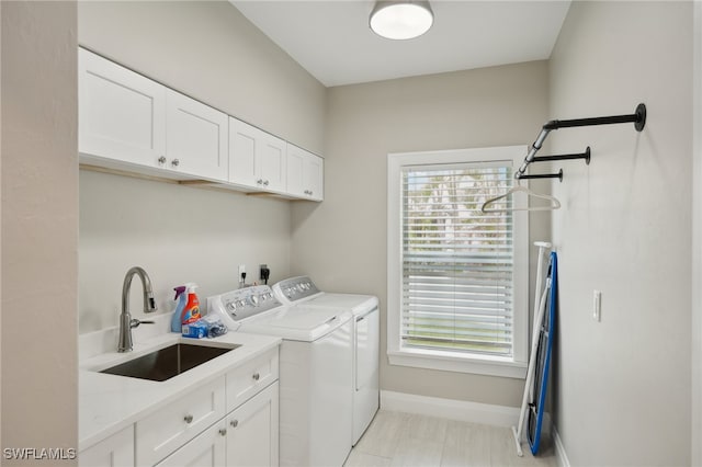 washroom with washing machine and dryer, sink, and cabinets