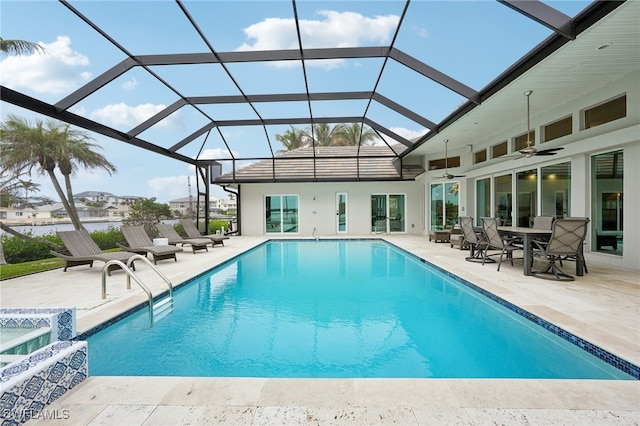 view of swimming pool with a patio, a lanai, and ceiling fan