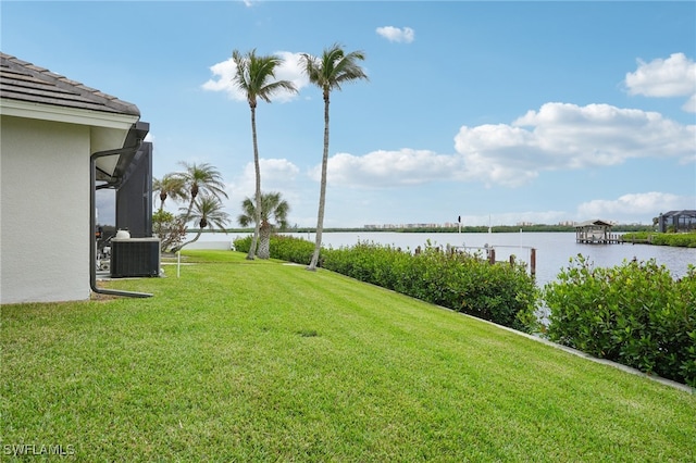 view of yard with a water view and central AC unit