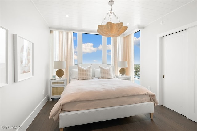 bedroom with multiple windows, dark hardwood / wood-style floors, and wooden ceiling