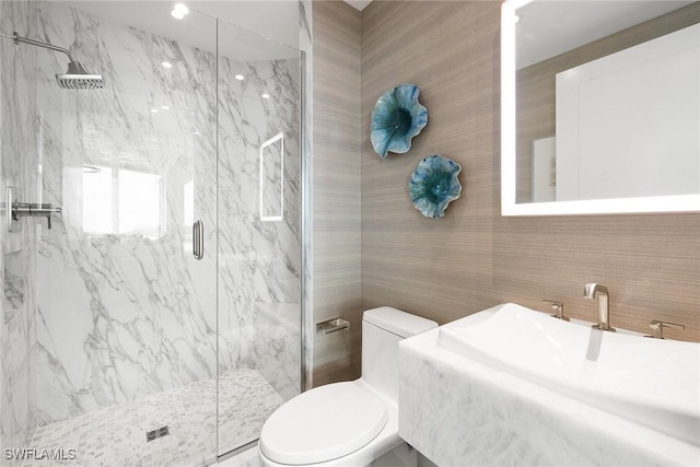 full bath featuring tile walls, a marble finish shower, toilet, and vanity
