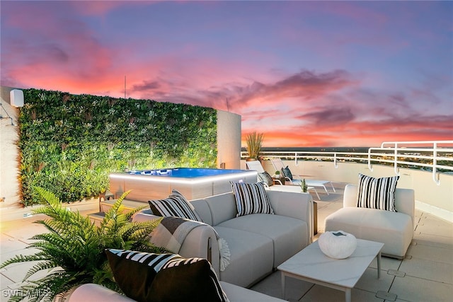 patio terrace at dusk featuring a water view and an outdoor hangout area