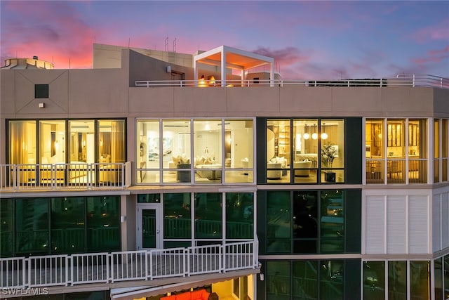 back house at dusk with a balcony