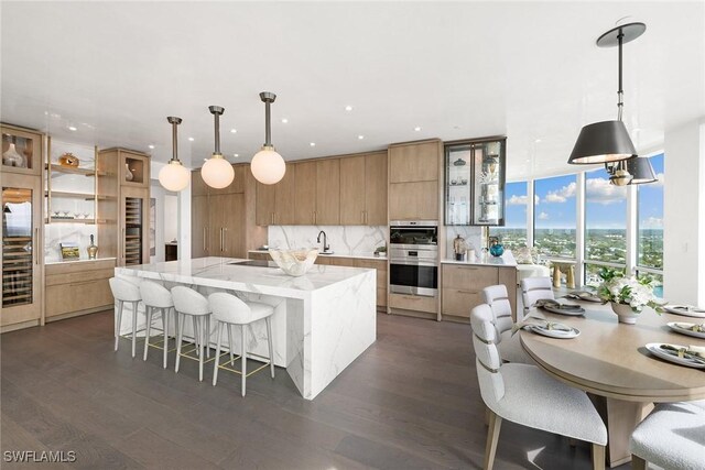 kitchen featuring a spacious island, pendant lighting, dark hardwood / wood-style floors, and stainless steel double oven