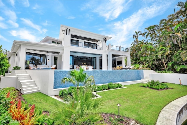 rear view of house featuring a lawn and a balcony