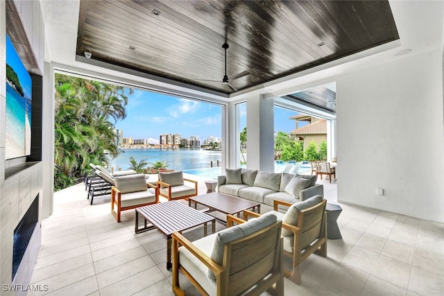 view of patio / terrace with a water view, ceiling fan, an outdoor hangout area, and a swimming pool