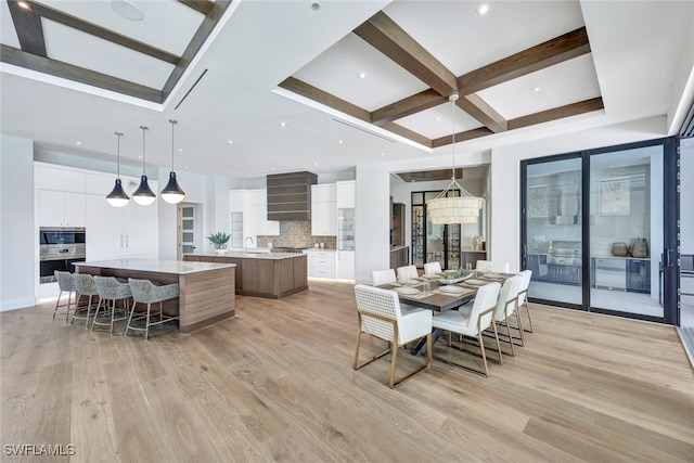 dining area with coffered ceiling, sink, beam ceiling, and light wood-type flooring