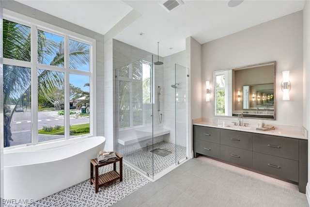 bathroom featuring tile patterned flooring, shower with separate bathtub, and vanity