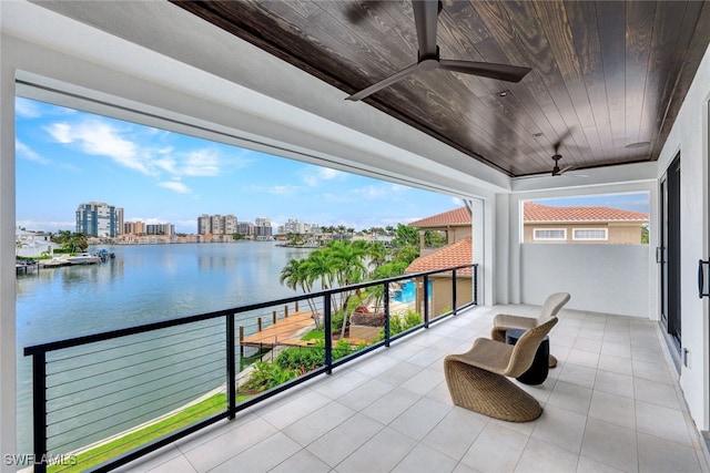 balcony with a water view and ceiling fan