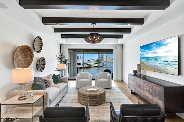 living room featuring beam ceiling, a chandelier, and light wood-type flooring