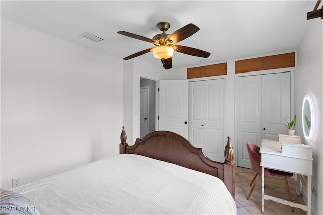 bedroom featuring two closets, light tile patterned floors, and ceiling fan