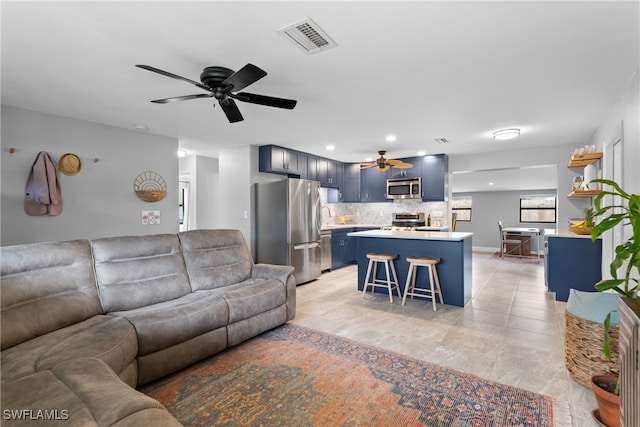 living room featuring ceiling fan, sink, and light tile patterned floors