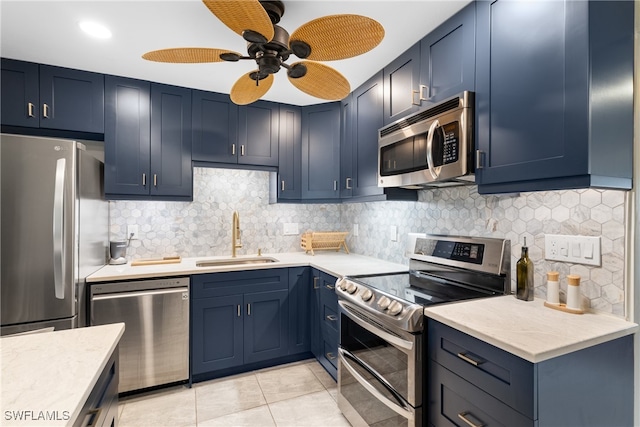 kitchen with appliances with stainless steel finishes, tasteful backsplash, sink, and light tile patterned floors