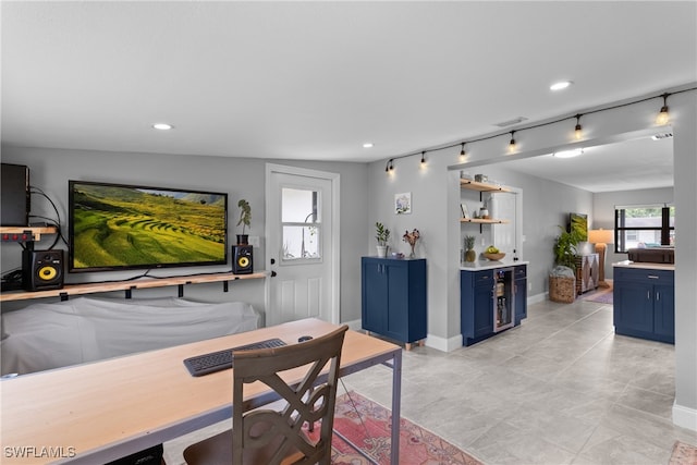 dining room featuring rail lighting and lofted ceiling