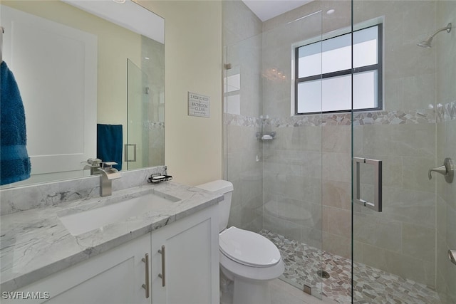 bathroom featuring an enclosed shower, vanity, and toilet