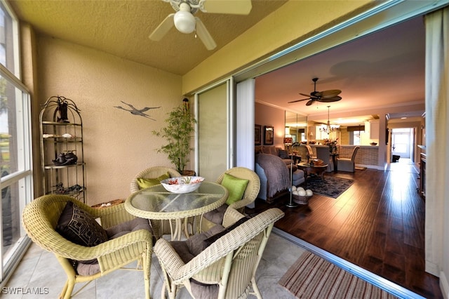 sunroom / solarium with ceiling fan with notable chandelier