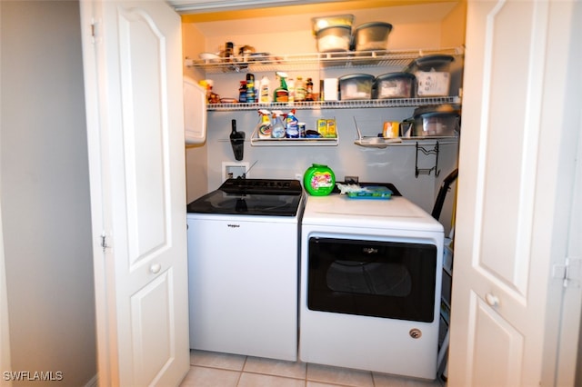 washroom with light tile patterned floors and washing machine and dryer