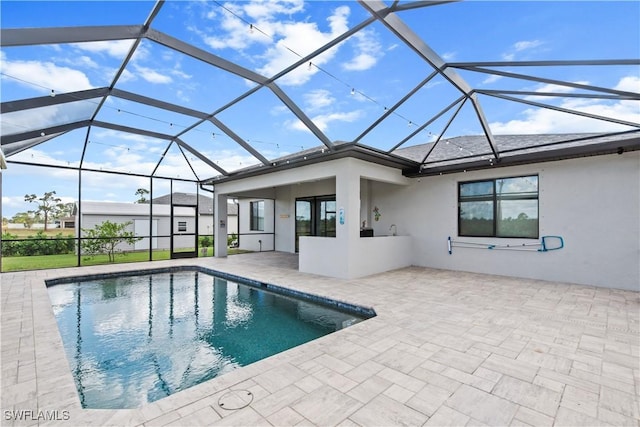 view of swimming pool featuring a patio area and glass enclosure