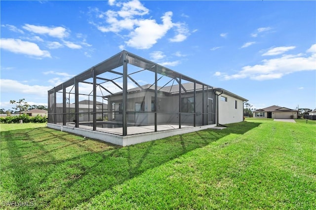 rear view of property featuring a patio area, a lanai, and a lawn