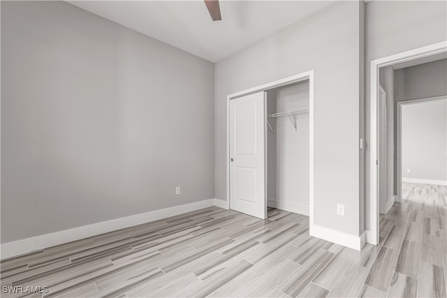 unfurnished bedroom featuring ceiling fan, a closet, and light hardwood / wood-style flooring