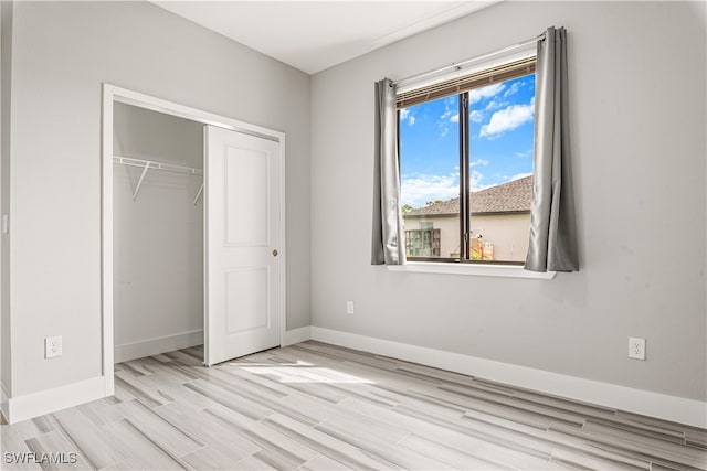 unfurnished bedroom featuring light wood-type flooring and a closet