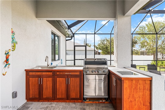 view of patio / terrace with a lanai, exterior kitchen, a grill, and a wet bar