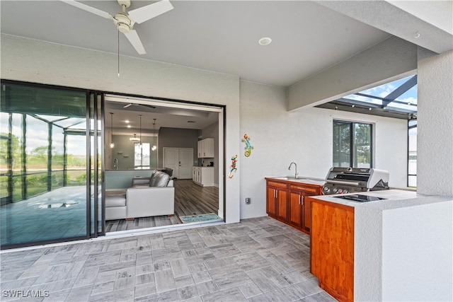 interior space with area for grilling, sink, ceiling fan, a lanai, and grilling area