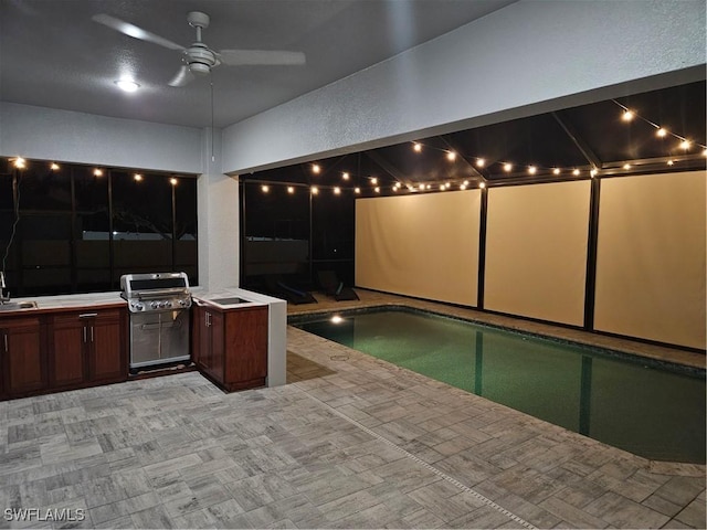 view of swimming pool with a patio area, an outdoor kitchen, sink, ceiling fan, and area for grilling