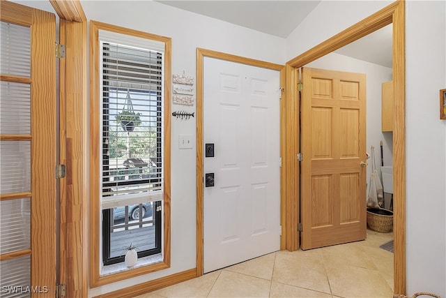 entryway featuring vaulted ceiling and light tile patterned floors