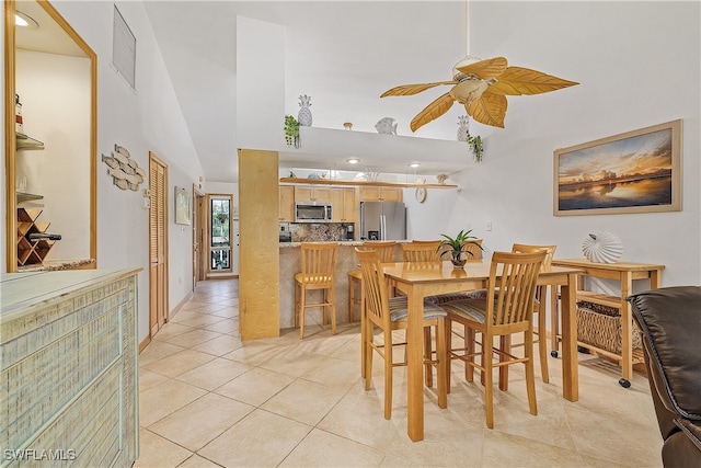 dining room featuring light tile patterned flooring, high vaulted ceiling, and ceiling fan