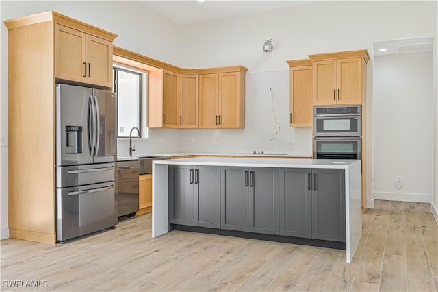 kitchen with a kitchen island, light hardwood / wood-style flooring, sink, gray cabinetry, and stainless steel appliances